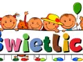 Uśmiechnięte dzieci trzymają tablicę z napisem "Świetlica". To miejsce, gdzie zgodnie z prawem oświatowym, dzieci spędzają czas po lekcjach.