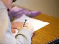 Uczeń pisze test maturalny, skupiony na zadaniu. Szkoła w chmurze matura to przyszłość edukacji.
