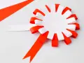 Papierowy kotylion w biało-czerwonych barwach, gotowy do ozdobienia. Idealny szablon do stworzenia patriotycznego akcentu.