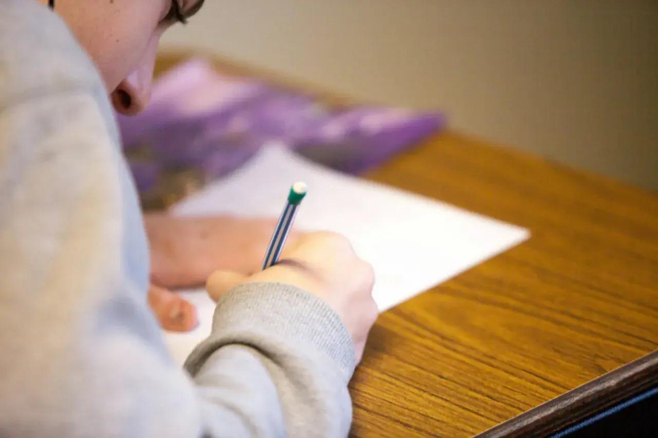 Uczeń pisze test maturalny, skupiony na zadaniu. Szkoła w chmurze matura to przyszłość edukacji.