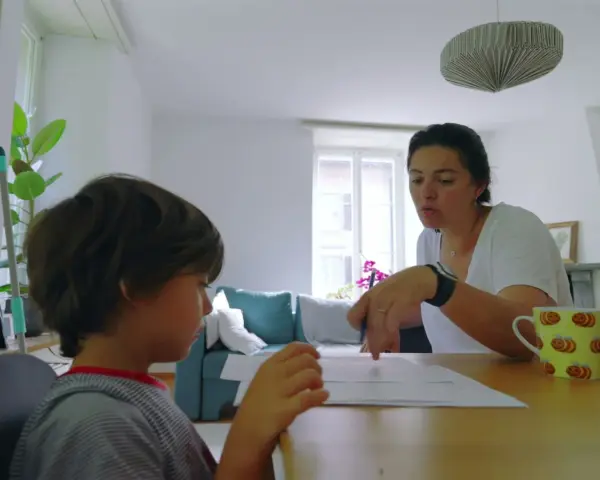 Mama tłumaczy synowi, co to są zgłoski, podczas wspólnej nauki.