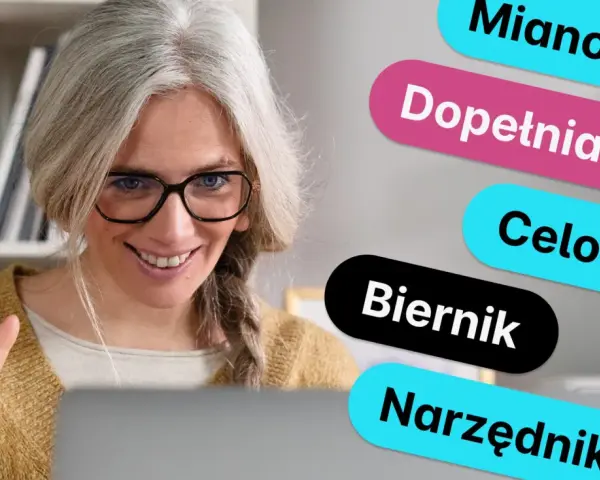 Kobieta z siwymi włosami i okularami uśmiecha się, pokazując trzy palce. Obok niej kolorowe napisy: Mianownik, Dopełniacz, Celownik, Biernik, Narzędnik – to rzeczownik od czasownika.