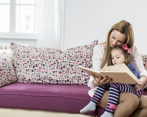 Mama czyta dziecku bajki terapeutyczne. Różne rodzaje bajek pomagają w rozwoju emocjonalnym.