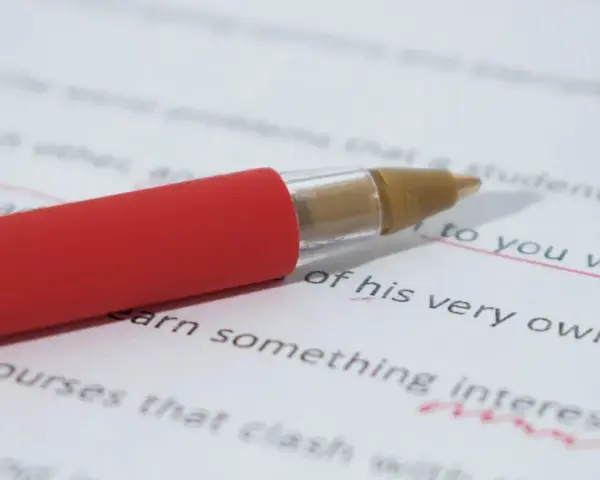 Czerwony długopis poprawia tekst, podkreślając "to you why". Czy przed "ze względu" stawiamy przecinek? To pytanie, na które szukamy odpowiedzi.