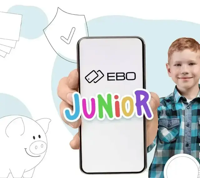 Chłopiec z uśmiechem trzyma telefon z napisem EBO Junior. Obok świnka skarbonka i stos banknotów. Idealne rozwiązanie na kieszonkowe dla 18 latka.