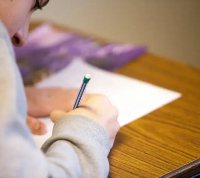 Uczeń pisze test maturalny, skupiony na zadaniu. Szkoła w chmurze matura to przyszłość edukacji.